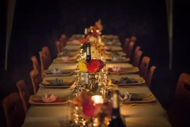 Long candlelit banquet table set with flowers