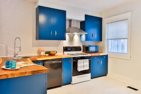 Navy blue kitchen cabinets with wooden worktops