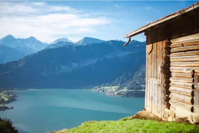 Alpine lake and mountains with a wooden cabin