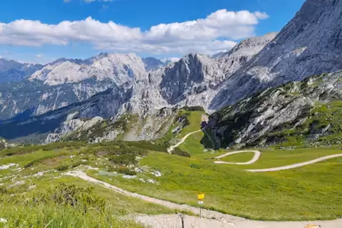 Green alpine valley with a winding trail